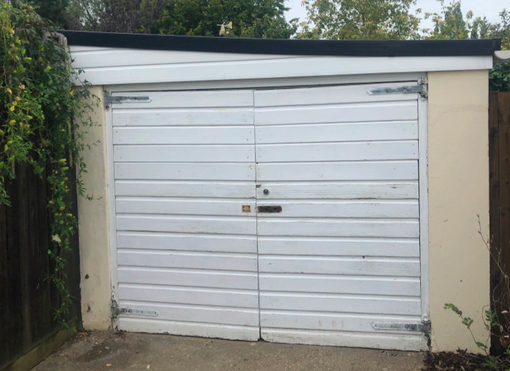 An old white, side-hinged garage door.