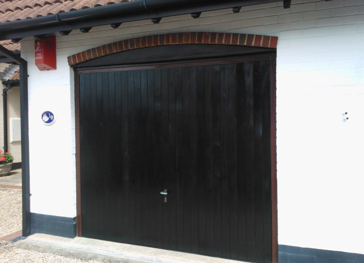 A black side-hinged garage door.