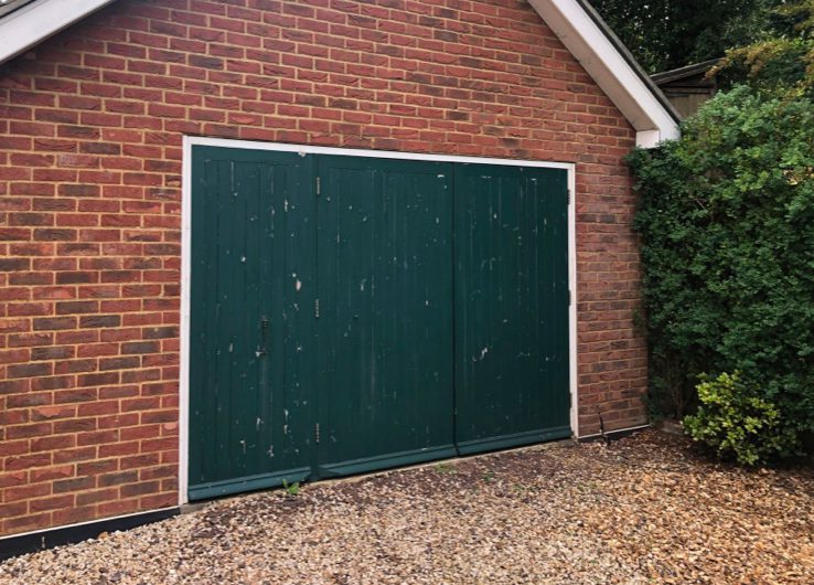 An old green side-hinged garage door.