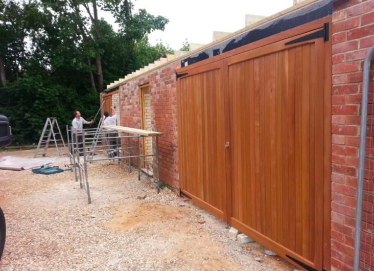 New wooden side-hinged garage doors being fitted.