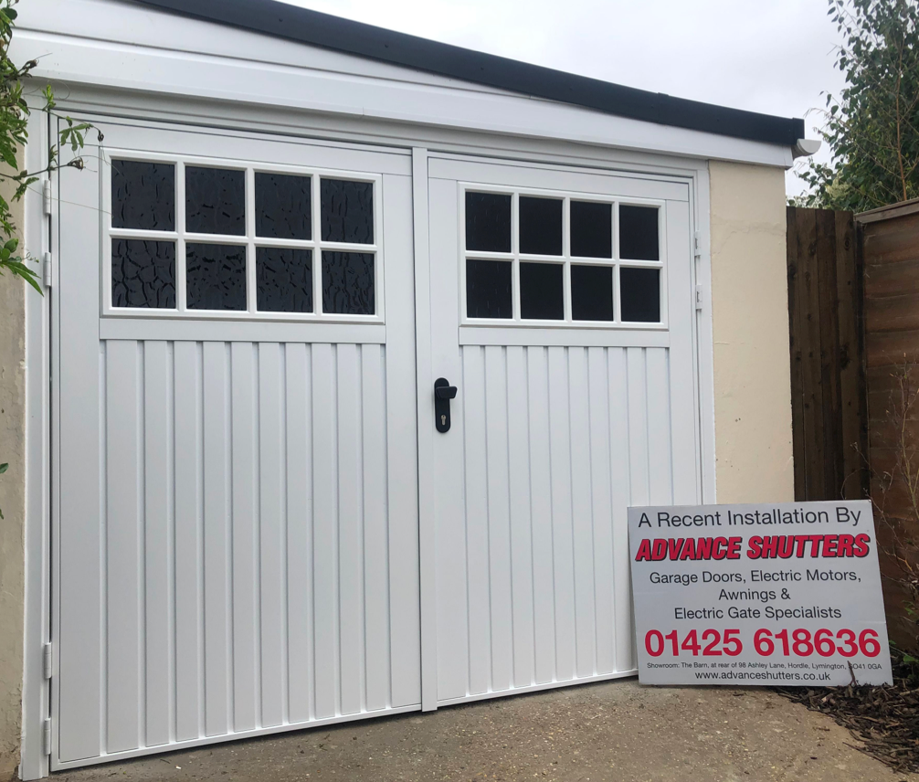 New fitted white side-hinged garage doors.