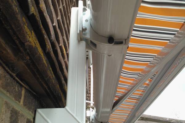 Photo of an awning bracket attached to a house wall.